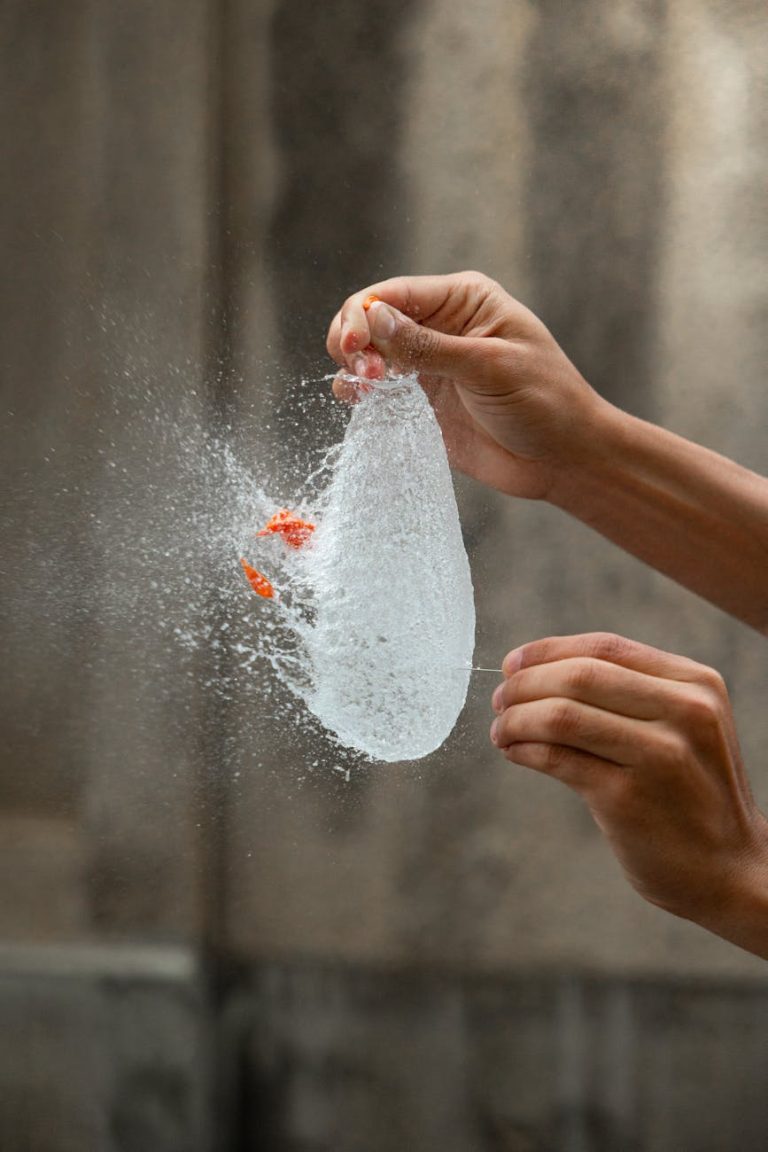 High-speed capture of a water balloon bursting midair, showcasing the dynamic water splash.